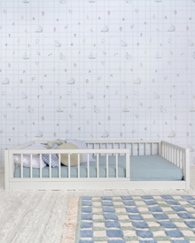 Cama Palito Evolutiva com Gavetões 4 em 1 na cor Off White, vista em ângulo no quarto, sobre tapete xadrez.
