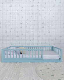 Cama Palito Evolutiva com Gavetões 4 em 1 na cor Azul, vista em ângulo no quarto, com grade lateral.