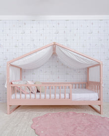 Cama Casinha Palito Evolutiva 4 em 1 na cor Rosa, com a estrutura de casinha e dossel de tecido, vista em ângulo.