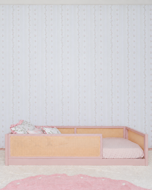 Cama Palha Evolutiva 4 em 1 na cor Rosa, vista em ângulo no quarto, com grade lateral.