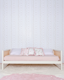 Cama Palha Evolutiva 4 em 1 na cor Off White, vista em ângulo no quarto, arrumada com almofadas.