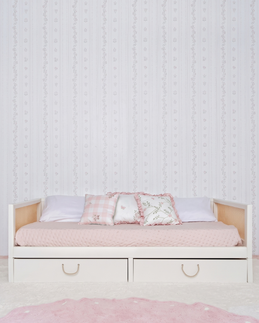 Cama Palha Evolutiva com Gavetões 4 em 1 na cor Off White, vista em ângulo no quarto, arrumada com almofadas.