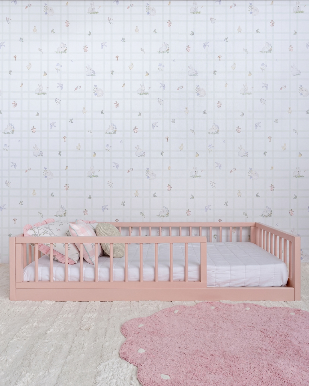 Cama Palito Evolutiva com Gavetões 4 em 1 na cor Rosa, vista em ângulo no quarto, com grade lateral.