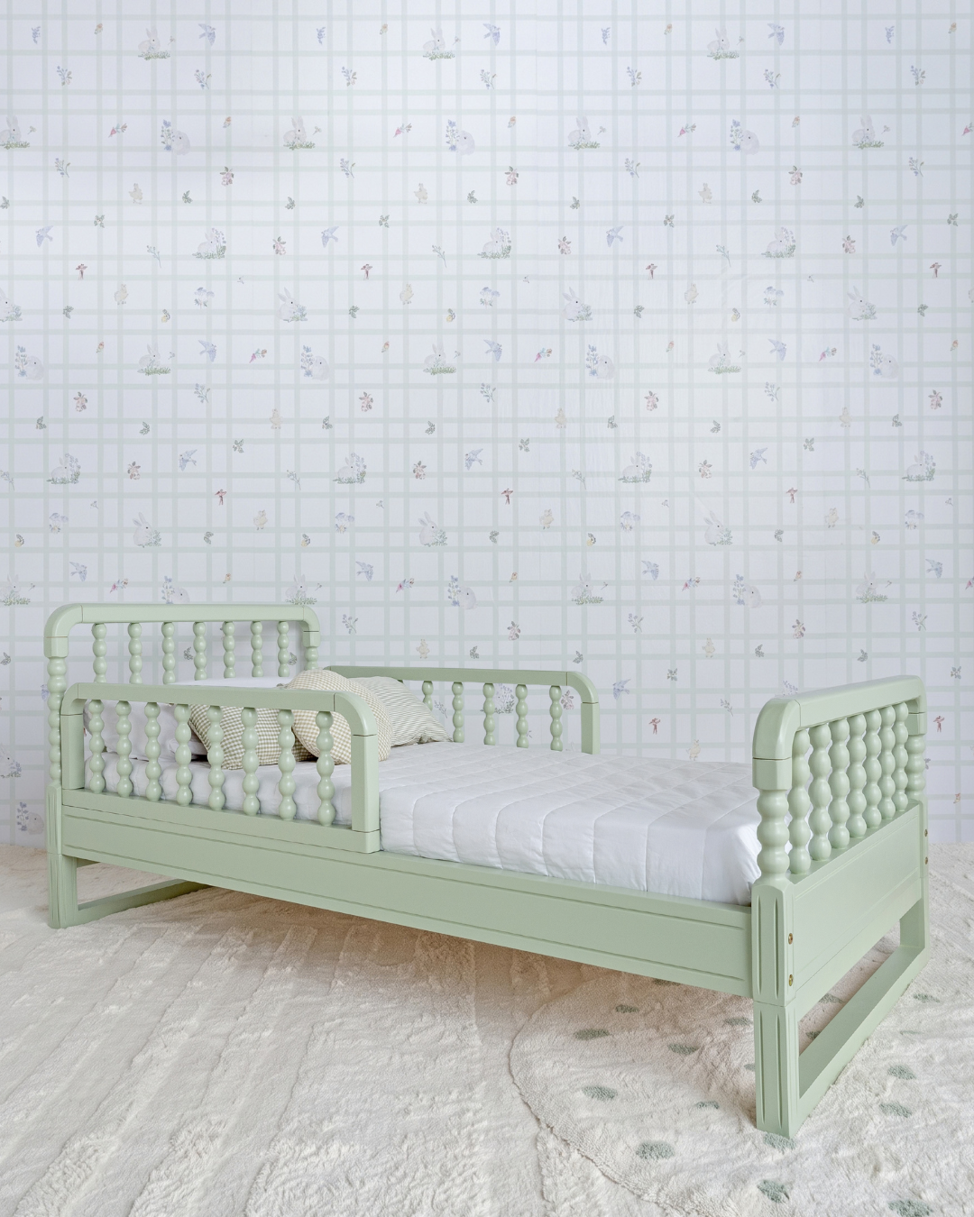 Cama Poema 3 em 1 na cor Verde, vista em ângulo no quarto, com grade lateral.