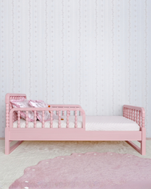 Cama Poema 3 em 1 na cor Rosa, vista lateral no quarto, com grade.