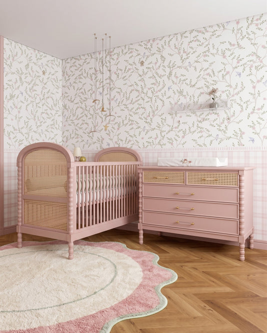 Berço Lorde Inglês com Palha na cor Rosa, no quarto, ao lado da cômoda da mesma cor.